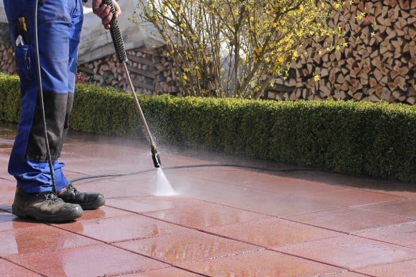 Bird-control-expert-cleaning-a-building-patio-with-water-and-bird-control-cleaning-agent