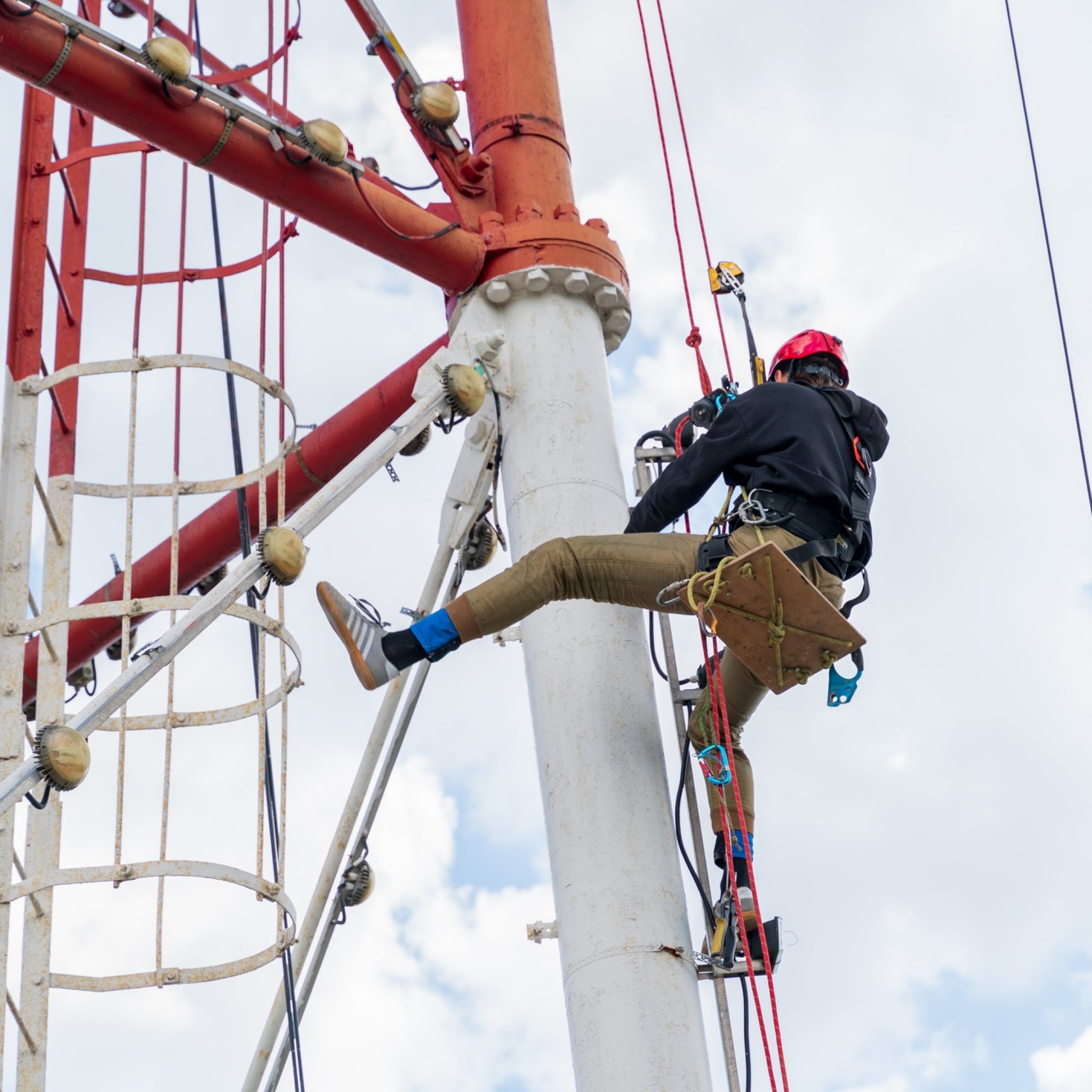 a-worker-with-climbing-equipment-serves-a-city-tv-tower-work-at-a-high-rise-facility-