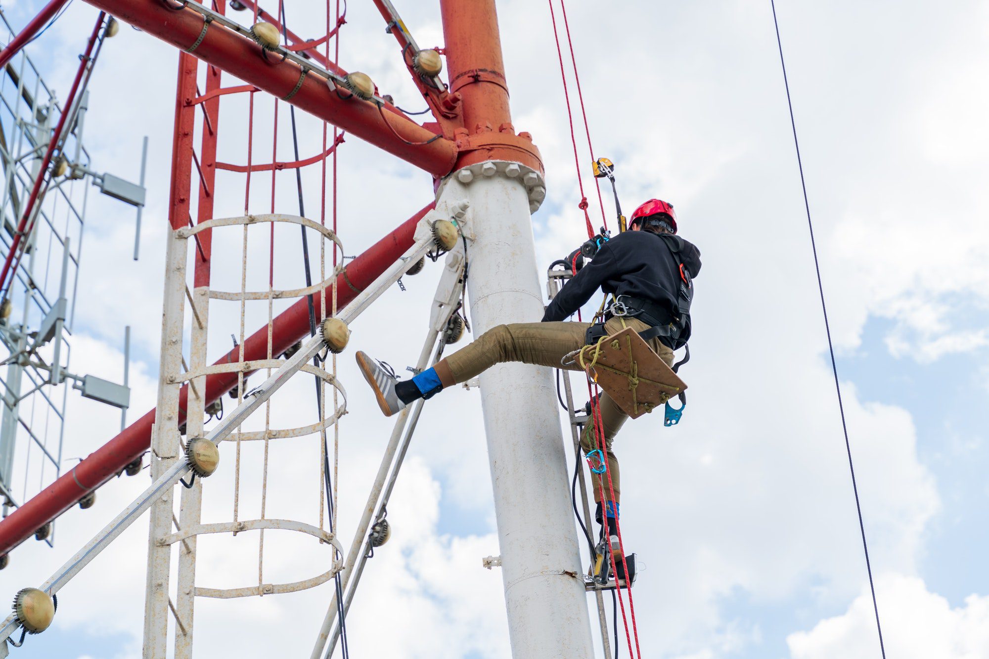 a-worker-with-climbing-equipment-serves-a-city-tv-tower-work-at-a-high-rise-facility-